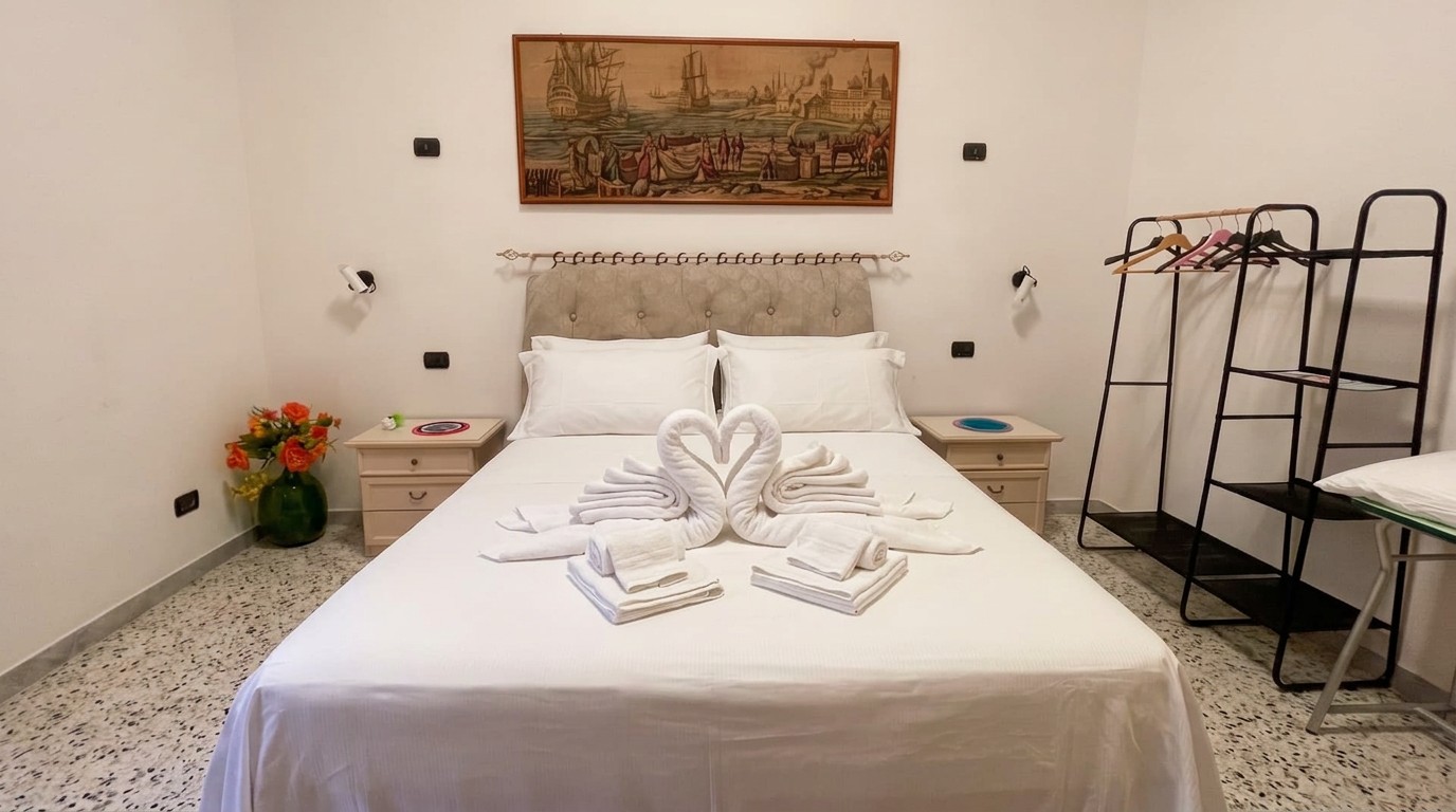 Camera matrimoniale chiara con biancheria preparata sul letto